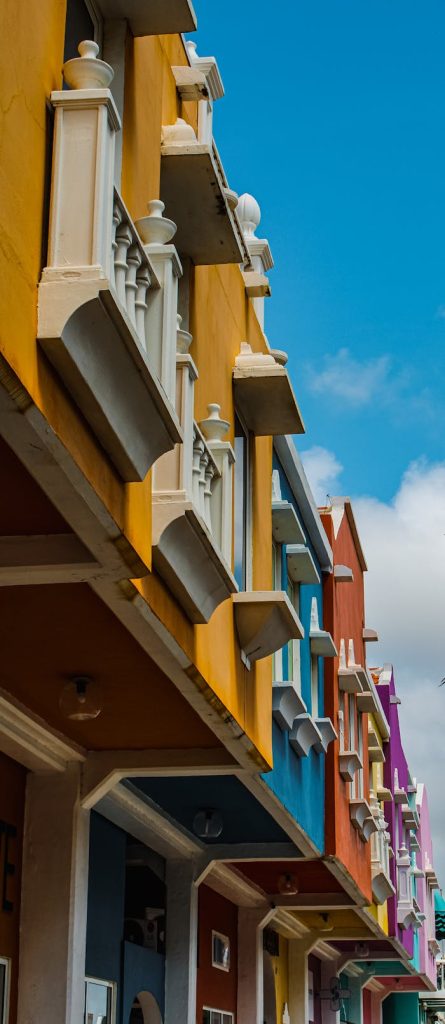 Shot of vibrant, colorful building facades in Willemstad showcasing Dutch-influenced architecture under a sunny sky.